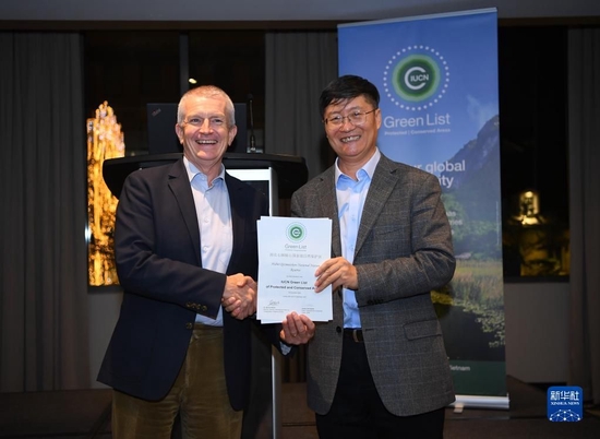 12月10日，在加拿大蒙特利尔，中国自然保护地代表（右）获颁证书。新华社记者 任鹏飞 摄