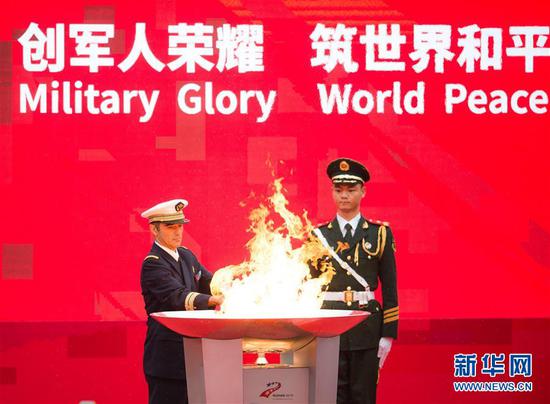 10月16日，国际军事体育理事会主席赫尔维·皮奇里洛（左）点燃第一支火炬。当日，第七届世界军人运动会火炬传递活动在武汉东湖绿道举行。新华社记者 肖艺九 摄