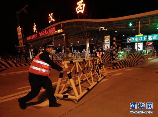 4月8日凌晨，在武汉西高速收费站，工作人员移除围栏。 新华社记者 沈伯韩 摄