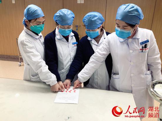 武汉市江夏区人民医院医护人员在请战书上按下手印。