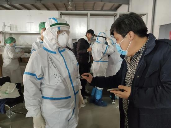 工作人员在张伯礼院士防护服上写“老张加油”