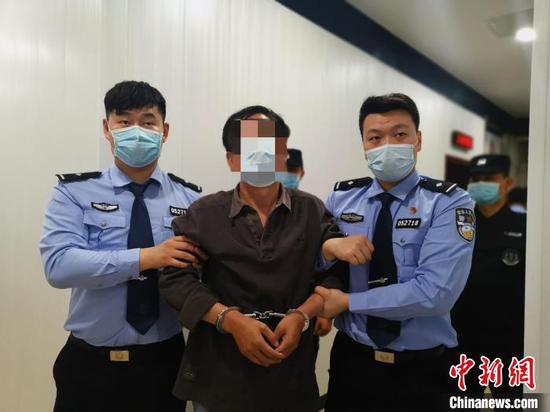 图为犯罪嫌疑人刘某被警方押解回荆州。荆公宣