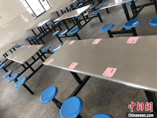 安置点食堂座位贴有号码牌,方便错峰间隔就餐 梁婷 摄