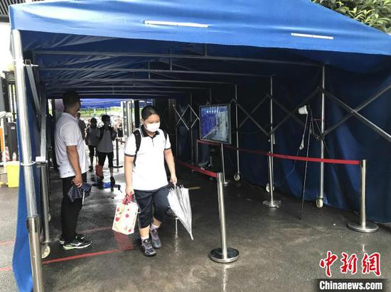 10日清晨,武汉二中广雅中学学生经过测温通道进入校园 张芹 摄