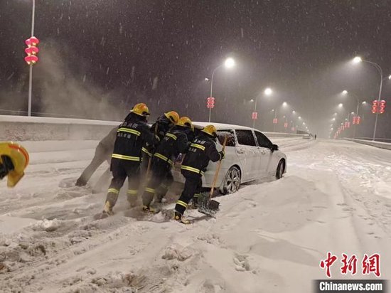2月4日，湖北孝感消防救援人员正在救援被积雪困住的车辆。陈叶摄