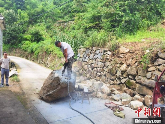 当地干部群众开展灾后道路清障保畅工作。 陈琦 摄