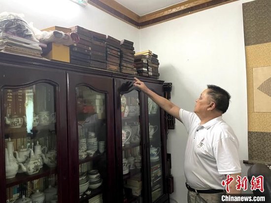 明平友展示其收藏的中国算盘。徐大发 摄