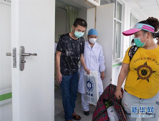 6月17日，胡定江在医护人员的陪护下走出病房。新华社记者 肖艺九 摄