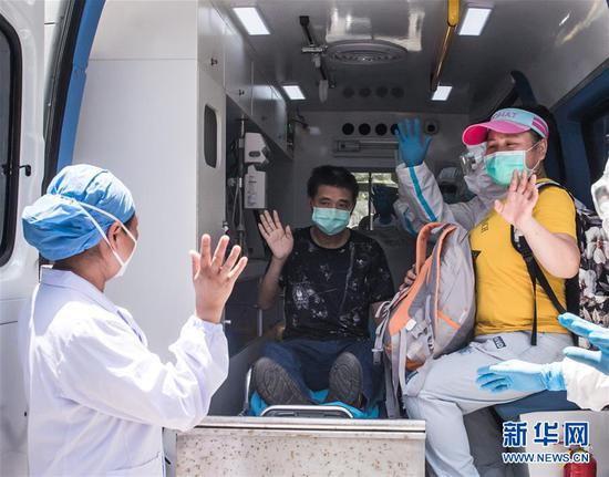 6月17日,胡定江在出院时向医护人员挥手告别。新华社记者 肖艺九 摄