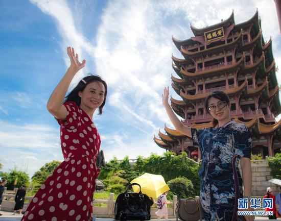  2020年8月7日，受邀来湖北旅游的海南援鄂医疗队员陈小妹（左）与同事计超在黄鹤楼景区观光。湖北省组织“与爱同行 惠游湖北”活动，陆续邀请援鄂医护人员代表以及湖北医护人员、社区工作者、志愿者等走进景区，饱览荆楚风貌。新华社记者 肖艺九 摄