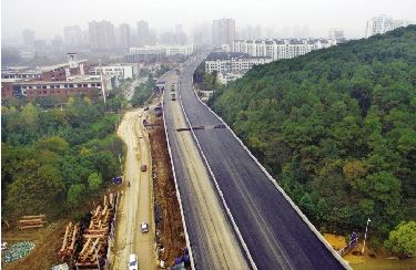 昨日,喻家湖北路至团山隧道入口处大部分路面已刷黑。 本报记者 王筝 摄