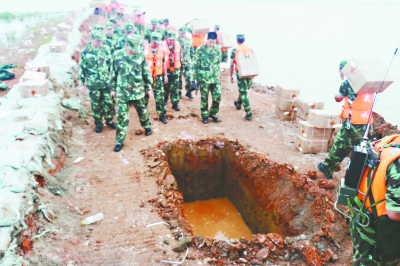 武警水电部队官兵在坝顶开挖药槽，然后填埋炸药   巢量 摄
