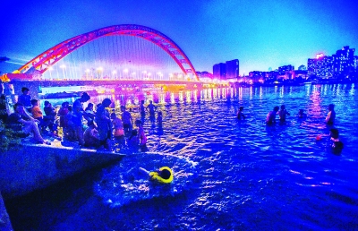 连日阴雨天气后，江城再度放晴。近日，许多市民夜晚来到晴川桥下江边游泳，玩水降温。记者许魏巍 摄