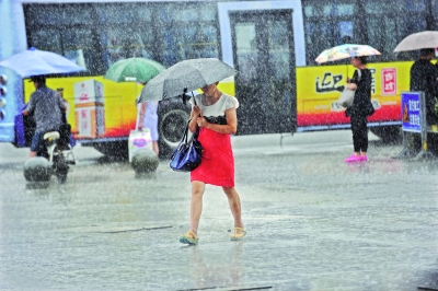 昨日午后,即将“出梅”的江城再次迎来一场强降雨,汉口武胜路街头,行人在大雨中压伞前行
苗剑 摄