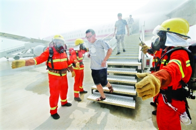 天河機場第二跑道正式啟用在即，昨日，來自武警、消防、公安、醫(yī)療等單位的600人組成聯(lián)合演習隊伍，在機場第二跑道舉行應急救援與反恐防暴演練。應急救援與反恐防暴兩個演練合并舉行，實機實彈演練，全過程約40分鐘。圖為“旅客”在公安、消防人員引導下迅速轉移至安全區(qū)域。