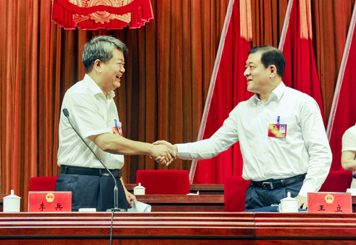 市委书记李兵与新当选为市长王立亲切握手表示祝贺。记者方仲华摄