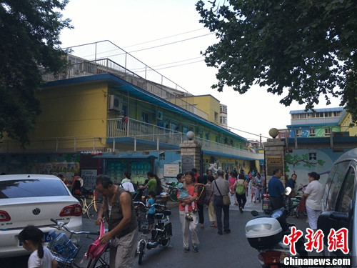 北京某幼儿园门口，家长接孩子放学。汤琪 摄