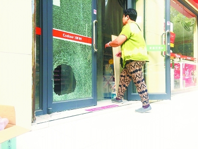 图为被砸破的超市玻璃门。记者张全录 摄