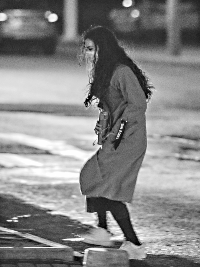 昨晚，寒风来袭，一位市民紧裹大衣过马路。 记者胡冬冬 摄