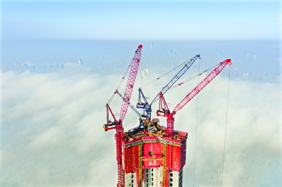 昨日，江城被浓雾笼罩，在400多米高的绿地中心楼顶塔吊处，可见蓝天白云，鸟瞰城市宛如雾海  记者胡九思 摄