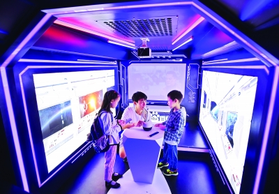 “科普大巴”内,两位小朋友与智能机器人对话 记者郭良朔 摄