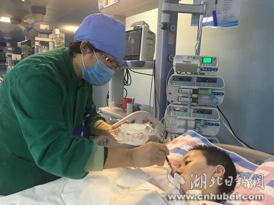汉阳医院重症医学科医护人员与娄滔耐心交流,并喂流食。(记者 龙华 视界网 赵林 摄)
