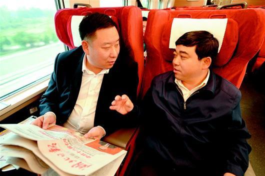 图为:15日,出席党的十九大的湖北代表乘坐高铁赴京。(记者 张磊 摄)