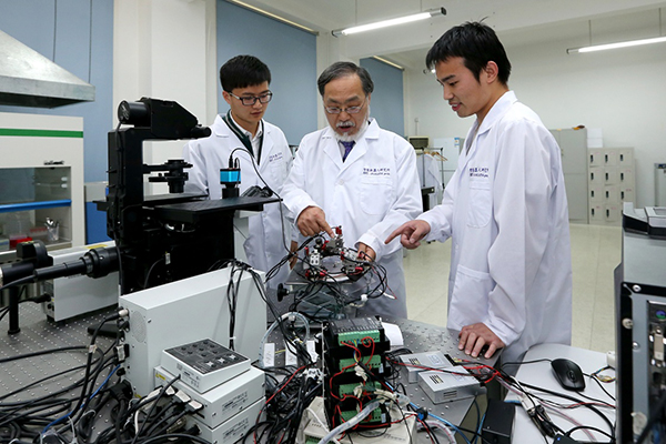 2016年4月18日，日籍科学家福田敏男（中）与学生在北京理工大学的实验室内。新华社 资料图