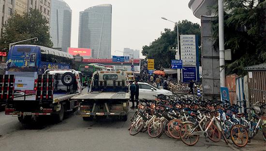 两辆拖车正准备将共享单车拖走。