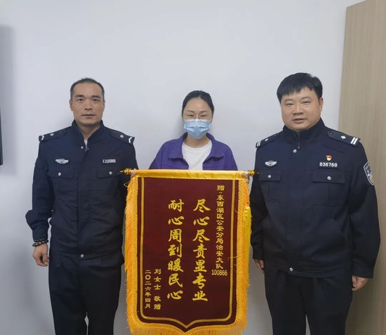 刘女士(中)给杨敬楠(左)送锦旗。