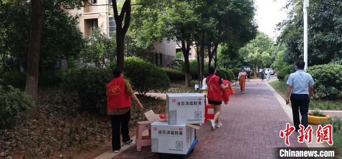 圖為志愿者在封控管理小區(qū)配發(fā)中藥藥劑　受訪者供圖