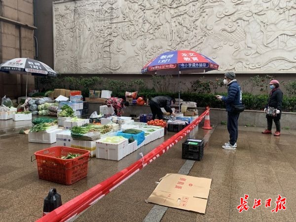 28日上午8点50分,华清园居民冒着零星小雨在临时菜场买菜。 记者汪峥摄