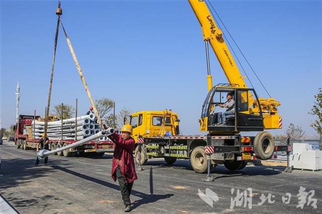 11月14日,中国一冶建设者正在吊装江滩路灯杆。