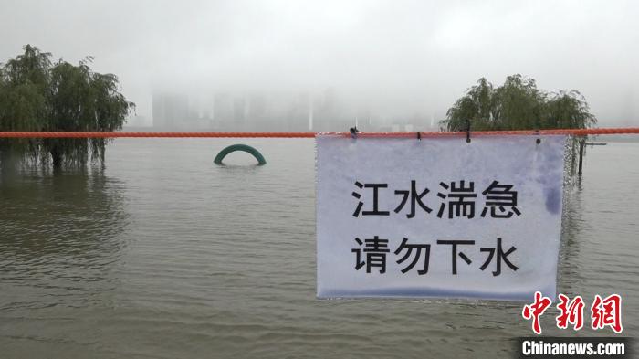 工作人員在江邊拉起紅色警戒線，提醒市民不要下水 張芹 攝