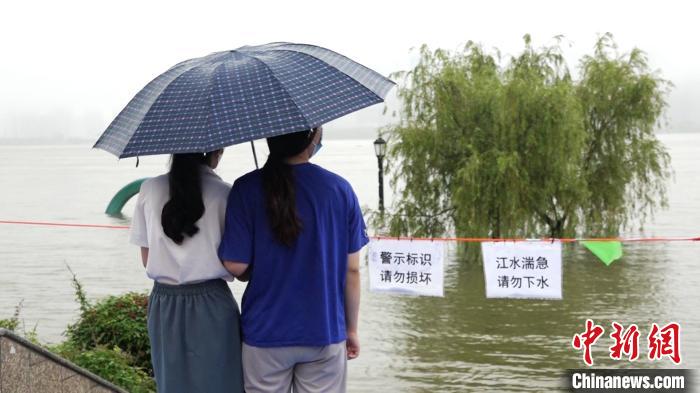 7月8日上午，汉口江滩二级亲水平台已被江水淹没，一些市民来到江边观江景　邹浩　摄