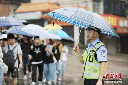 6月7日，2019年高考首日，地处广西北部山区的融安县出现强降雨过程，考生风雨中奔赴考场，参加高考。谭凯兴 摄