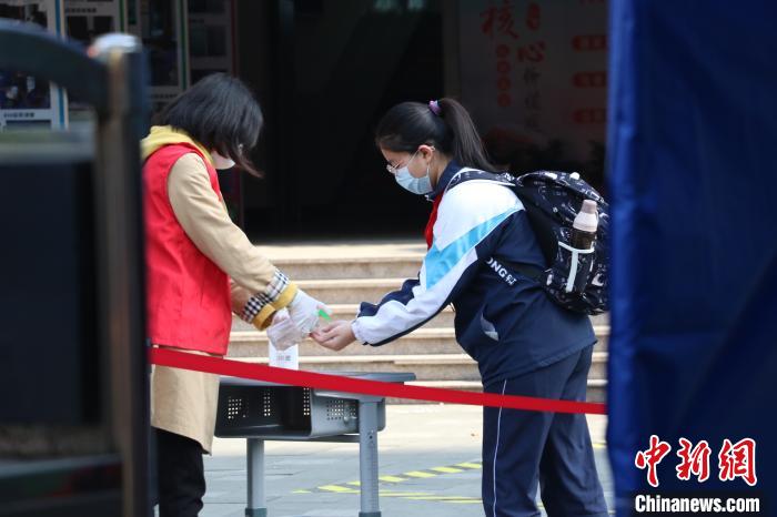 学生进校前用免洗洗手液消毒。 童笑雨 摄