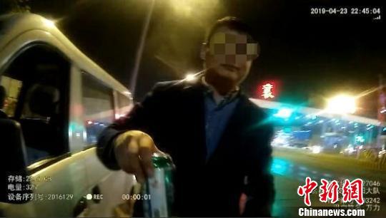 駕駛員王某從駕駛室里拿出半罐啤酒遞給民警(視頻截圖)受訪單位提供