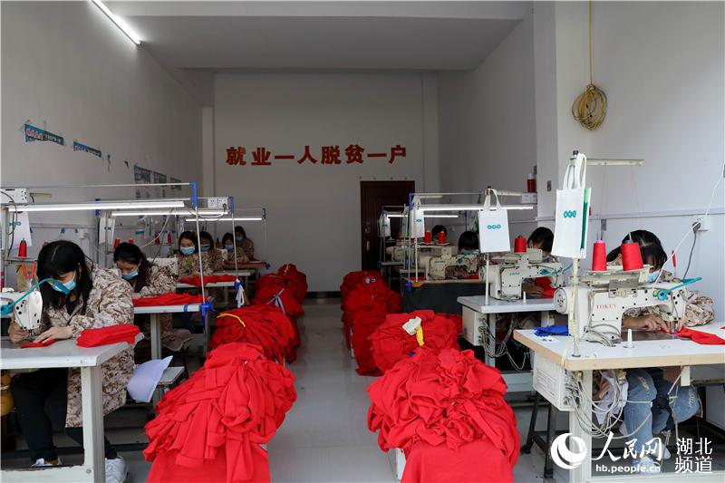 5月3日,湖北省鹤峰县走马集镇容合制衣部生产车间里,员工们正在赶制销往广州的服装订单。(汪正玺 摄)