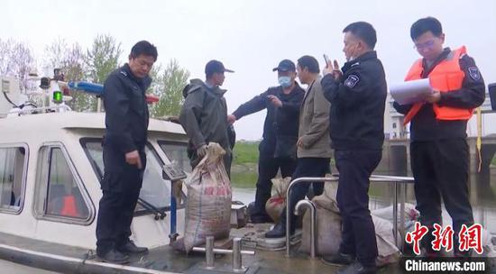 图为执法人员发现汉川市经济开发区神灵口村附近水域有人捕捞螺蛳。 宋博　摄