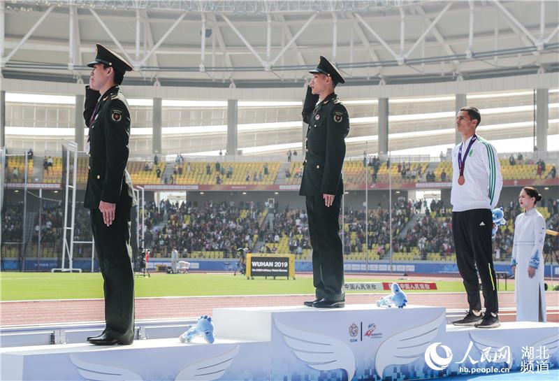 　　获得金牌的中国选手王嘉男（左二）、获得银牌的中国选手黄常州（左一）在领奖台上向国旗敬礼。