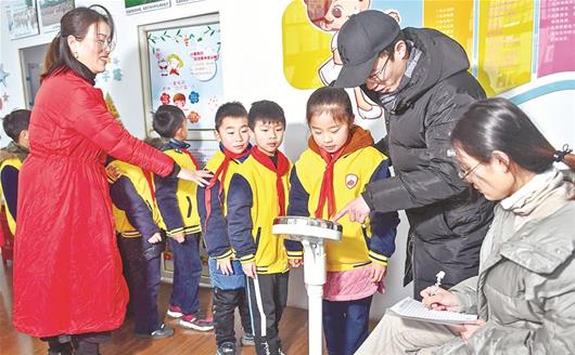 图为:吴家山四小足球队的学生们在测量体重 楚天都市报记者黄士峰摄