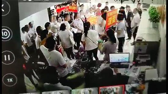 有人举着“东湖壹号物业滚蛋”的牌子 业主及东湖壹号提供视频截图