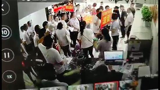 有人舉著“東湖壹號(hào)物業(yè)滾蛋”的牌子 業(yè)主及東湖壹號(hào)提供視頻截圖