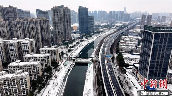 图为武汉市黄孝河明渠及清理积雪后的道路。　邹浩 摄