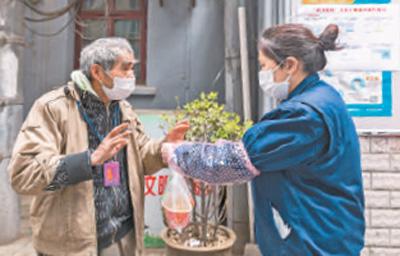 赵媛（右）为社区独居老人送早餐。 张武军摄