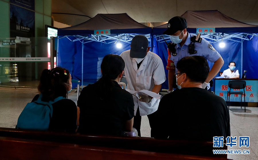 8月1日，从郑州返回武汉的旅客在武汉火车站接待服务点进行登记申报。新华网发 赵军摄