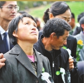 汪耀峰的母亲走到儿子的遗像前仰望