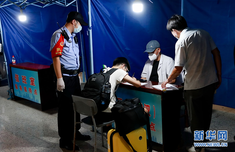 8月1日，从上海返回武汉的一境外旅客在武汉火车站接待服务点进行登记申报。新华网发 赵军摄