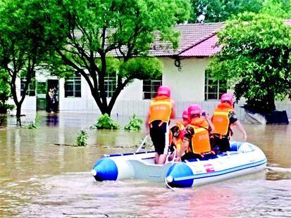 图为：昨日，持续强降雨导致当阳市子龙村一家四口被洪水围困，消防官兵利用橡皮艇将他们救出。 通讯员刘邦沛摄